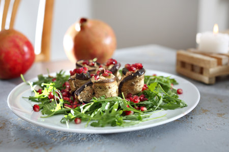 Salad with grilled aubergine. Eggplant roulades with cheese served with pomegranate on rocket lettuce.の写真素材