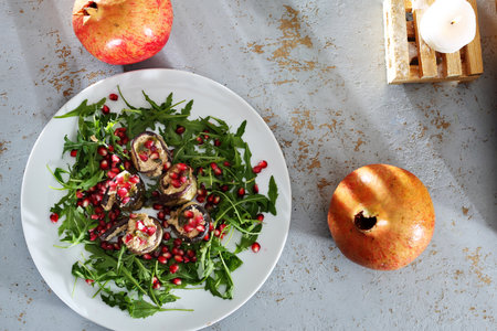 Eggplant rolls. Eggplant roulades with cheese served with pomegranate on rocket lettuce.の写真素材