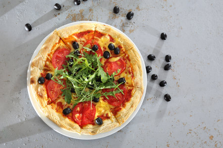 Italian pizza. Pizza with tomatoes, black olives, arugula.の写真素材