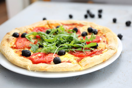 Pizza with mozzarella and tomatoes. Pizza with tomatoes, black olives, arugula.の写真素材