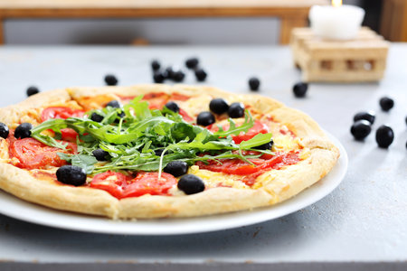 Colorful pizza. Pizza with tomatoes, black olives, arugula.の写真素材