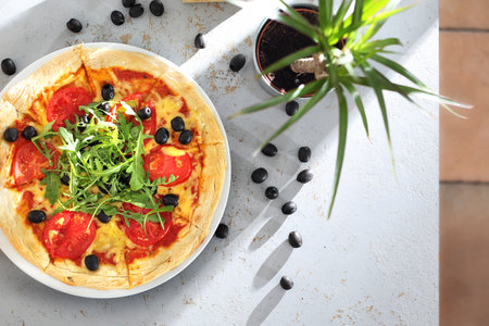 Italian pizza. Pizza with tomatoes, black olives, arugula.の写真素材
