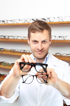 Optical salon. The man chooses the spectacle frames in the optical salonの写真素材