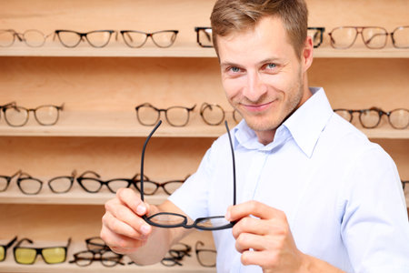 Defect of vision. The man chooses the spectacle frames in the optical salonの写真素材