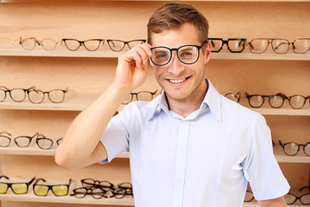 Glasses. Facial glasses. The man chooses the spectacle frames in the optical salonの写真素材
