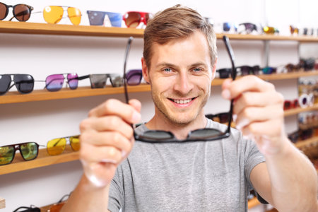 Sunglasses. The man is trying on glasses.の写真素材