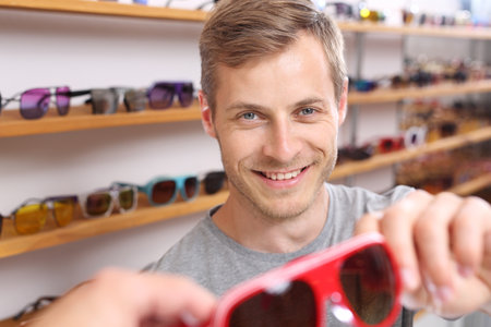 Sunglasses. The man is trying on glasses.の写真素材