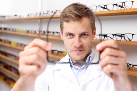 Glasses. The man chooses the spectacle frames in the optical salonの写真素材