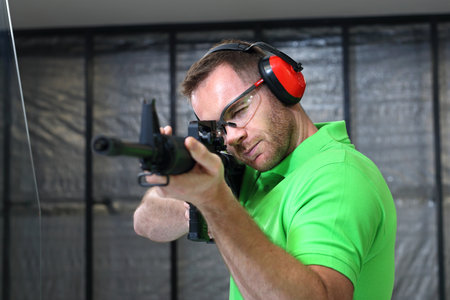 Shooting range. Handsome man trains shooting at the sports shooting range.