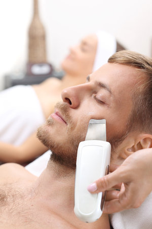 Cavitation peeling, male care. A man in a beauty salon on a facial skin cleansing procedure.の写真素材