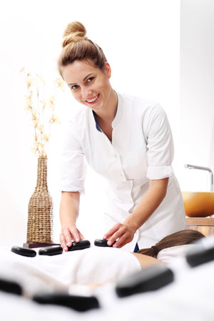 Massage with stones for lovers. A woman sitting on a massage in a spa salon.の写真素材