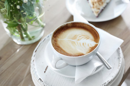 Coffee with milk. A cup of hot coffee with a beautiful finish on the foam.の写真素材
