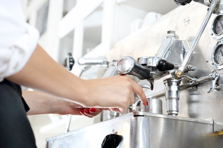 Coffee from the machine. Waitress prepares coffee in a professional pressure espresso machine.の写真素材