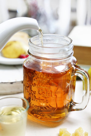 Tea. Pouring tea from a jug into a glassの写真素材