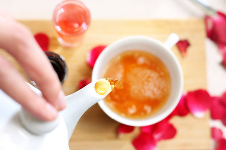 Floral tea. A woman pours tea into a cupの写真素材