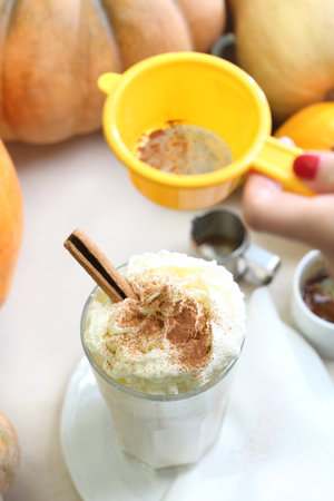 Coffee with cinnamon. Tasty coffee with milk and whipped cream on the background of autumn pumpkins.の写真素材