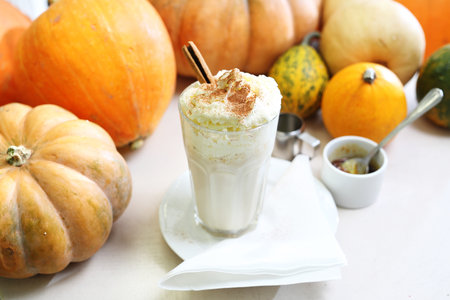 Coffee dessert. Tasty coffee with milk and whipped cream on the background of autumn pumpkins.の写真素材