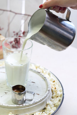 Cafe latte. A glass of coffee with milk and cream with the addition of popcorn.の写真素材