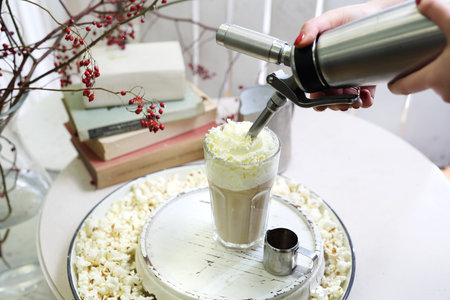 Ice coffee. A glass of coffee with milk and cream with the addition of popcorn.の写真素材