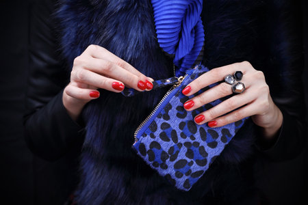 Stylish woman. An elegant woman in a fur coat is holding a purse in her hand.の写真素材