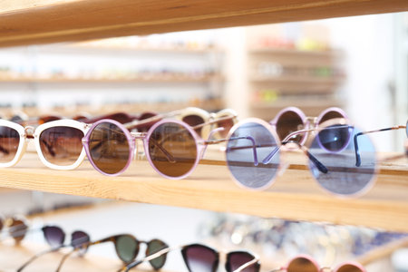Sunglasses, a fashionable addition to styling. Shelf with over-sun glasses in a clothing store.の写真素材