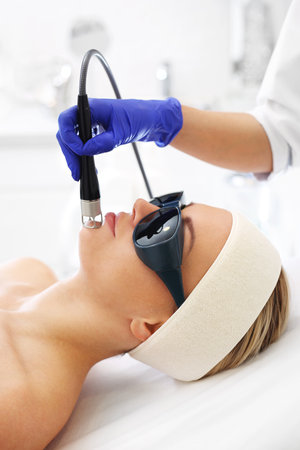 Photorejuvenation using a laser. A woman in a beauty salon during a laser treatment.の写真素材