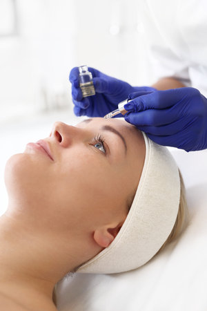 Vitamin in cosmetic ampoule. Beauty imposes on the woman's face cosmetic preparationの写真素材