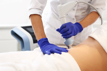A flat stomach, and firming treatment. The beautician performs the treatment using the machine.の写真素材
