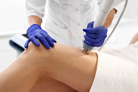 Body shaping, thigh firming. The beautician performs the treatment using the machine.の写真素材
