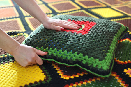 Needlework. Colorful woolen pillow and bedspread crocheted.の写真素材