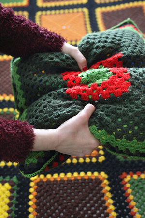 Needlework. Colorful woolen pillow and bedspread crocheted.の写真素材