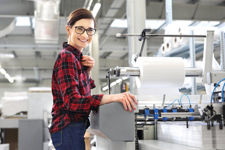 Printing house. A woman is working at a peeling machine.の写真素材