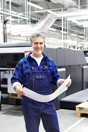 Printer. The man checks the print quality.の写真素材