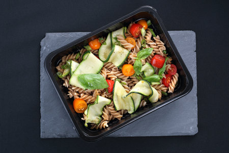 Delicious pasta salad with green lettuce, tomatoes and roasted chicken.の写真素材