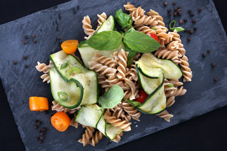 Delicious pasta salad with green lettuce, tomatoes and roasted chicken.の写真素材