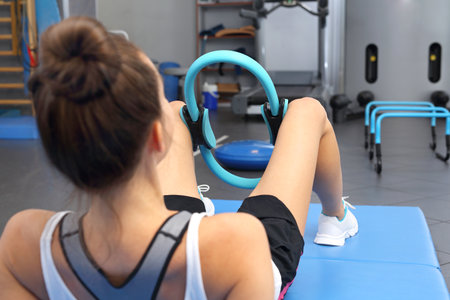 In the rehabilitation room a young woman trains the inner muscles of the thighs.の写真素材
