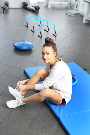 A young, attractive woman in an exercise room on a blue sports mattress.の写真素材