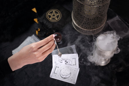 Fortune-telling, the fortune-teller puts tarot cards and spells the pendulum.の写真素材