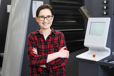 Printer. A smiling woman, an office worker  of modern printing machines.の写真素材