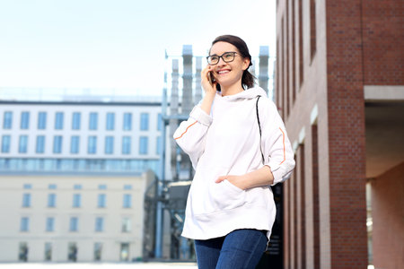 Smiling natural young woman talking on the phone.の写真素材