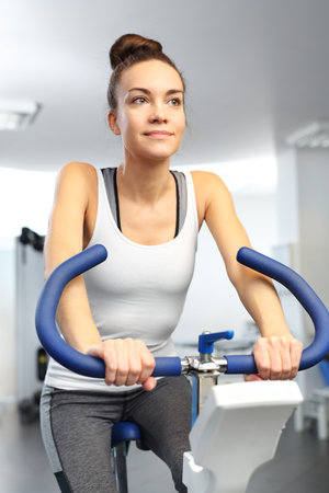 Riding a stationary bicycle .Spinning, Fitness club.の写真素材