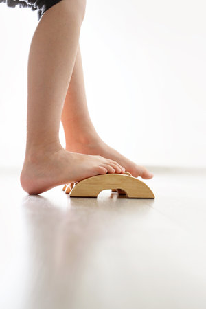 Feet of babys naked against the background of the wooden floor,  exercises against flat feet.の写真素材