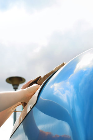 Recycling, a woman throws paper waste into a blue containerの写真素材