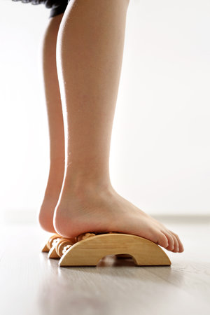 Feet of baby against the background of the wooden floor, exercises against flat feet.の写真素材