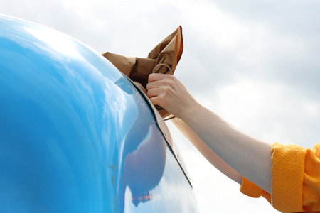 Recycling, a woman throws paper waste into a blue containerの写真素材