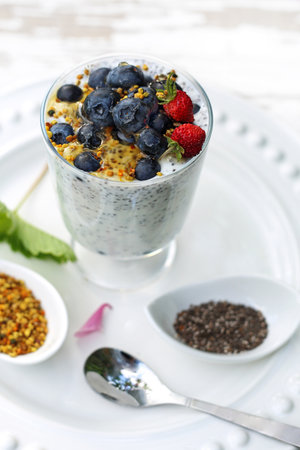 Healthy dessert. Yogurt with chia seeds, pollen and berries of wild strawberriesの写真素材