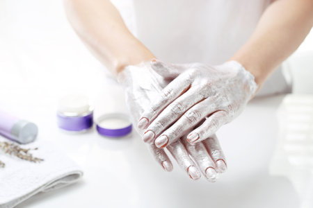 Hand spa. The woman puts a mask on the skin of the hand. Hand skin care.の写真素材