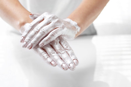 Hand spa. The woman puts a mask on the skin of the hand. Hand skin care.の写真素材
