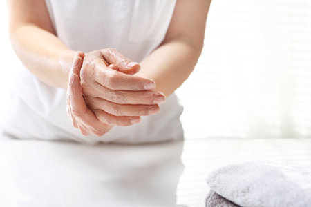 Hand spa. The woman peels the skin of the hand. Hand skin care.の写真素材