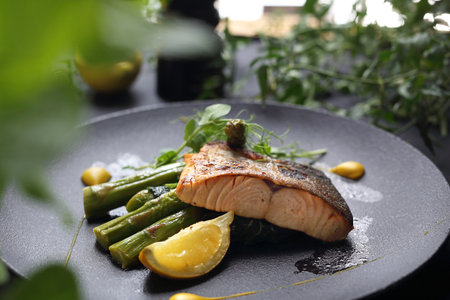The dish served on a black plate. An exquisite dishの写真素材